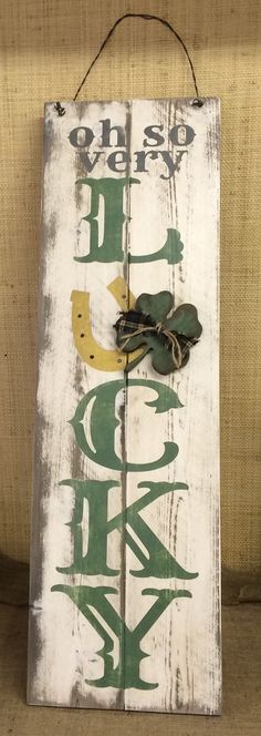 a wooden sign with the words oh so very lucky and an arrow hanging from it