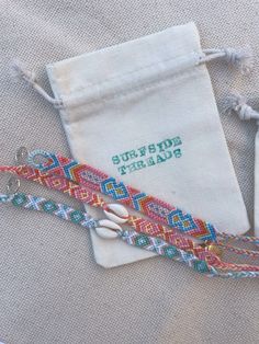 two bracelets are sitting next to a drawstring bag