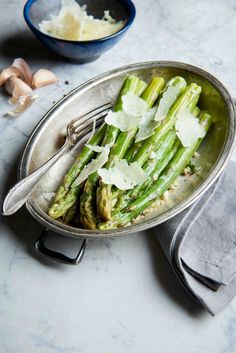 asparagus with parmesan cheese and garlic in a bowl on a table