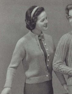 two women standing next to each other wearing sweaters