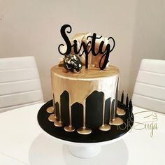 a black and gold cake sitting on top of a white table