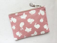 "This zipper pouch is made from cotton print. It is 100% cotton. This bag features white bunnies on a pink background. Fully lined with a light gray pin dot cotton fabric. Zipper is beige and the zipper pull is accessorized with a gold leaf shaped charm. Perfect purse for keeping small items such as compact digital camera, iPod, credit cards, etc. Dimensions (approx): Coin purse: 3.5\"H x 5\"W Pencil case: 4\"H x 8\"W (no depth) There is also a blue pouches available: https://www.etsy.com/listin Pencil Case Pink, White Bunnies, Bunny Silhouette, Compact Digital Camera, Perfect Purse, Japanese Cotton, Pink Stars, Toiletry Storage, Metal Charm