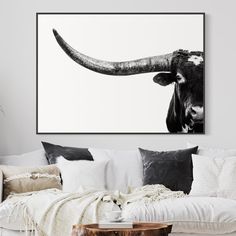 a black and white photo of a bull's head on a wall above a couch