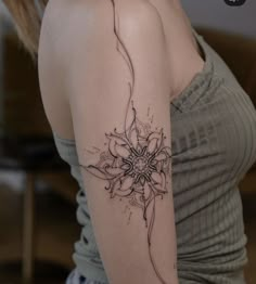 a woman's arm with a flower tattoo on the left side of her arm