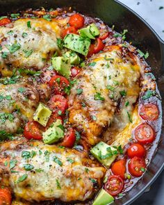 a skillet filled with chicken, tomatoes, avocado and other toppings