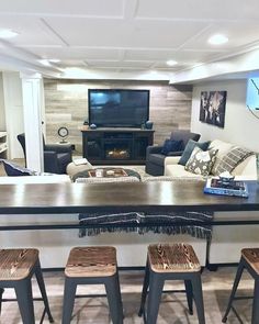 a living room filled with furniture and a flat screen tv mounted on the wall above a fireplace