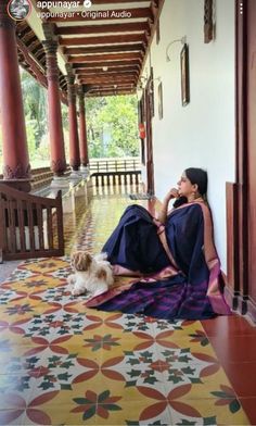 a woman sitting on the floor with her dog