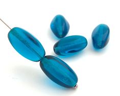 three blue glass beads on a white background