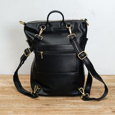 Carry everything you need with this timeless leather backpack. The bag is made with 100% vegan leather, making it durable and long-lasting. The convertible strap also allows you to easily switch between using the backpack or shoulder bag mode. Colors: Black & Sand Size: L 12.60" x H 14.20" x D 5.50" Material: Made with 100% Vegan Leather Origin: Imported The actual color of this product may vary slightly under different lighting conditions. Childrens Shop, Leather Making, Black Leather Backpack, Cool Notebooks, Melting Candles, Camping Accessories, Black Sand, Crossbody Tote, Wallet Accessories