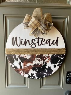 a door hanger that says,'winstead'with a bow on it