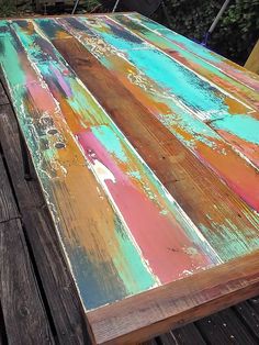 an old wooden table that has been painted with different colors