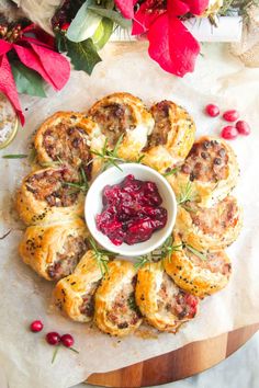 small pastries with cranberry sauce in a white bowl on a wooden platter