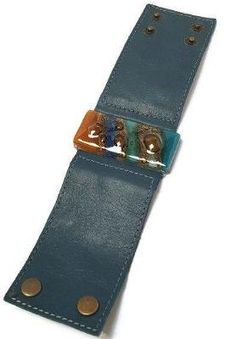 Amazing Handmade Leather cuff. Wide Leather Cuff. Dark green Leather Bracelet. Recycled glass Bracelet. Terracotta, teal brown, and blue cuff. All the leather used is reclaimed!! The leather is cut, glued, and stitched for durability. The band is real leather 2'' wide. The cuff is adjustable with 2 double snaps at approx 7'' and 7.6''. Although One size fits most this bracelet is on the bigger side. The glass bead is made of 3 layers of recycled fused glass. The glass is cut colored and painted. Adjustable Blue Leather Cuff Bracelet, Brown And Blue, Glass Bracelet, Leather Cuffs, 3 Layers, Recycled Glass, Green Leather, Handmade Leather, Glass Bead