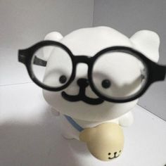 a close up of a toy with glasses on it's head and a bear