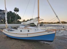 a sailboat sitting on top of a sandy beach