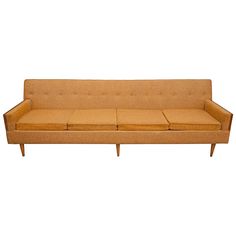 a tan couch sitting on top of a white floor