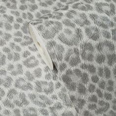 a close up view of a gray and white animal print fabric with an adhesive tape sticking out of it