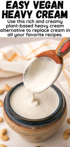 a spoon full of cream being lifted from a bowl with cashews around it