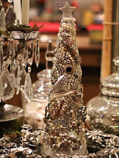 a table topped with lots of glassware and a christmas tree made out of beads