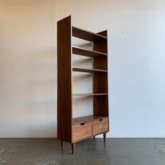 a wooden bookcase with two drawers on one side and an open drawer on the other