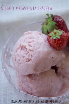 two scoops of ice cream in a bowl with strawberries on the top and bottom