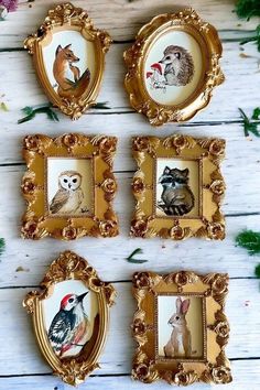 four gold frames with pictures of animals on them