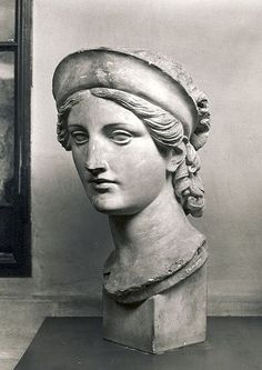 an old black and white photo of a bust of a woman