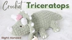 a crochet triceratos stuffed animal laying on top of a white blanket