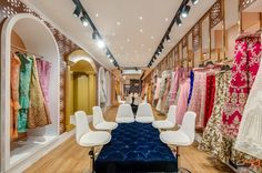 the inside of a clothing store filled with lots of different colored dresses and rugs