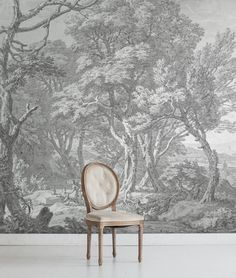 a chair sitting in front of a wall with trees on it