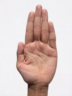 a person's hand holding up their palm with the middle finger extended to stop