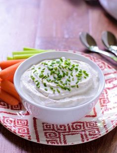 a plate with carrots, celery and dip on it