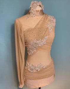 a mannequin is dressed in a beige dress with beading on the shoulders