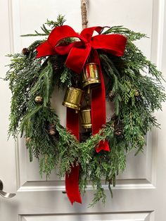 a christmas wreath with bells hanging on the front door