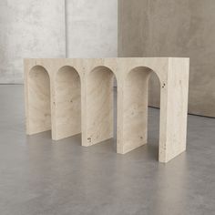 four stone arches sitting on top of a cement floor