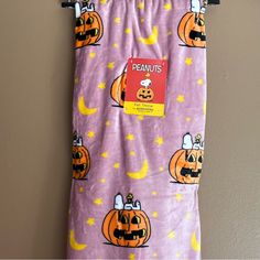 a purple towel with pumpkins on it hanging from a hook in front of a wall