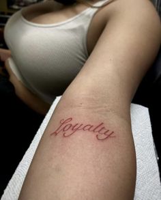 a woman's arm with the word beauty tattooed on it in cursive writing