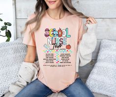 a woman sitting on a bed wearing a pink t - shirt that says school nurse