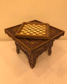 a wooden chess board sitting on top of a table