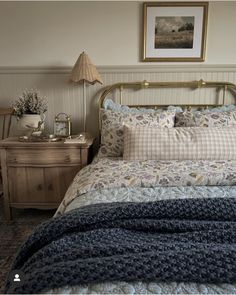 a bed sitting next to a nightstand with a lamp on top of it