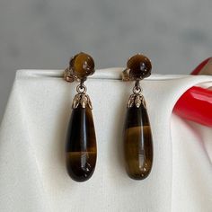 Glossy heavy teardrop tiger's eye dangle earrings set in yellow gold with a simple butterfly clasp.  Pre-loved item Stamped 14KT gold Size (approx.): 3.3cm long, 0.8cm wide Weight: 5.649g **FREE shipping within Canada and USA** If you have any questions or concerns, please do not hesitate to contact us. We will be more than happy to help you and answer any inquiries.  We invite you to check out our shop for more fabulous items! Simple Butterfly, Tiger Eye Earrings, Brown Stone, Teardrop Dangle Earrings, Eye Earrings, Tiger's Eye, 14kt Gold, Stone Earrings, Earrings Set