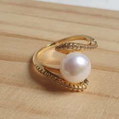 DESCRIPTION: This stunning 14K gold pearl engagement ring features a genuine pearl at its center, accented with sparkling diamond CZs. Dainty and elegant, it's the perfect proposal ring or a thoughtful gift for any occasion. BEST FEATURES: Crafted from high-quality gold, offering durability and a luxurious shine that lasts. Features a real freshwater pearl, known for its unique beauty and timeless appeal. Sparkling cubic zirconia accents enhance the ring's elegance, mimicking the look of diamond Gold Pearl Engagement Ring, Engagement Ring Dainty, Customer Gifts, Pearl Engagement Ring, Perfect Proposal, Real Pearls, Proposal Ring, Cute Gift, Sparkle Diamonds