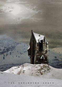 an old building sitting on top of a snow covered hill with mountains in the background