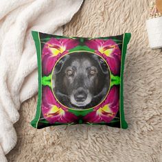 a black dog with pink and yellow flowers on it's face in a green frame