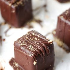 several pieces of chocolate sitting on top of a white tablecloth with gold sprinkles