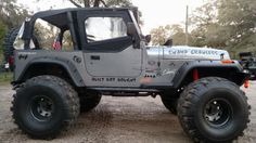 a gray jeep parked on top of a dirt road