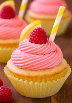 cupcakes with pink frosting and raspberries on top