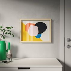 an abstract painting hangs on the wall next to a white dresser with green vases