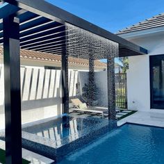 an outdoor swimming pool with a pergolated cover and lounge area in the background