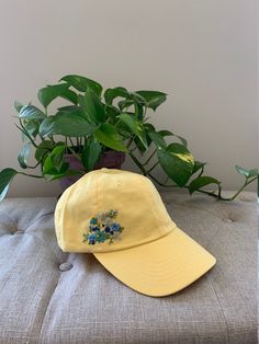 This listing is for one hand embroidered baseball cap. Various shades of blue flowers on green stems embroidered on a yellow cap. Each of my PetalStitchCo baseball cap designs is a one of a kind. They are inspired by the beautiful wildflowers I have in my Wisconsin garden. I am constantly creating new caps, so please check back often to see new listings. Hats are a cotton 'one size fits most" and can be sized with the adjustable metal slider on the back.  If you have any specific questions regarding the hats, please reach me through Etsy messages. This hat is ready to ship and will ship free via USPS first class mail. Priority mail is available as an upgrade at checkout. Please note that you will be provided with a tracking number which you may check via your order page or directly at www. Yellow Curved Brim Baseball Cap With Embroidered Logo, Yellow Flower-shaped Hats For Spring, Yellow Flower Hat For Spring, Yellow Baseball Cap With Curved Brim, Yellow Baseball Cap With Embroidered Logo, Yellow Baseball Cap For Spring, Yellow Dad Hat For Summer, Yellow Dad Hat Baseball Cap For Summer, Yellow Spring Cap Hat